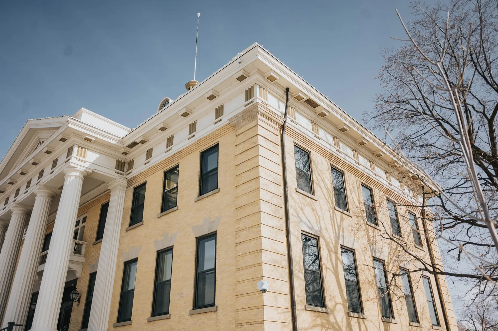Historic county courthouse with stone columns under a blue sky