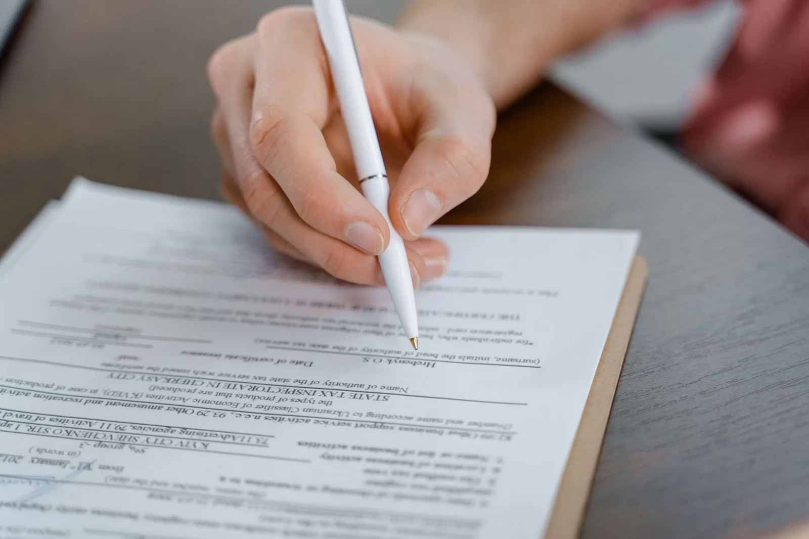 Hand signing a legal document with a fountain pen