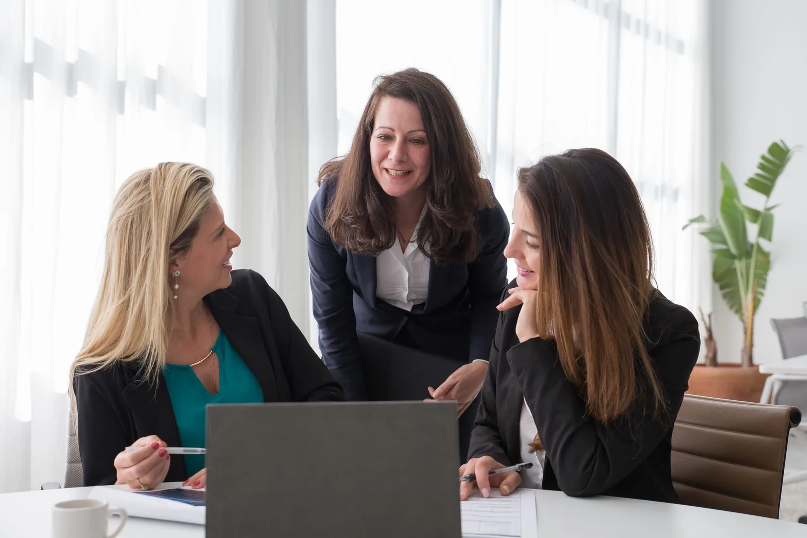 Three colleagues reviewing work together at an office table